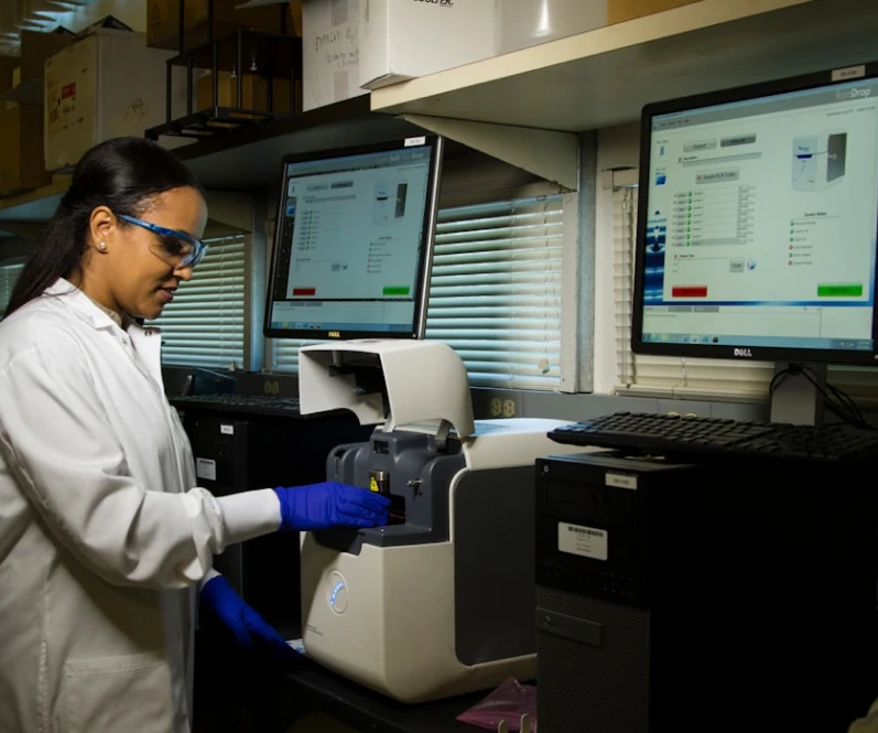 Scientist operating HPLC analysis equipment in a laboratory